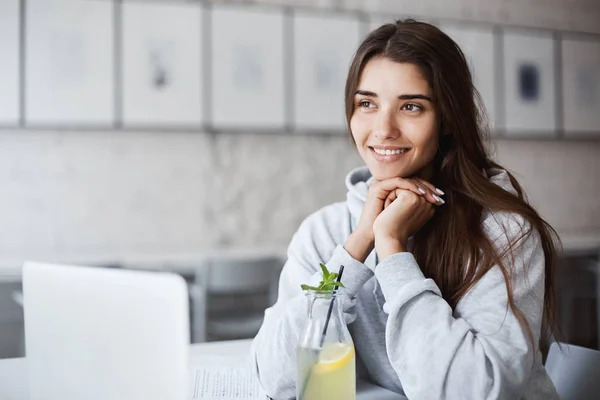 Siswa perempuan muda menggunakan laptop antara seminar untuk chatting dengan yang lain yang signifikan. Minum limun, tersenyum, memimpikan liburannya . — Stok Foto