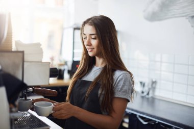 Genç kadın barista kahve sabah hazırlanıyor. Başarılı bir iş çalıştıran özveri gerektirir.