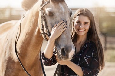 Portrait of beautiful woman petting a horse on animal farm or ranch dreaming to become a forage supplier. clipart
