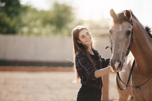 Jovem dona da fazenda cuidando de um cavalo em um rancho de animais em um dia de verão . — Fotografia de Stock