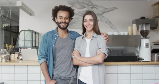 Feliz pareja de hombres y mujeres dueños de cafeterías corriendo un exitoso negocio de café y pastelería mirando a la cámara sonriendo en cámara lenta — Vídeos de Stock