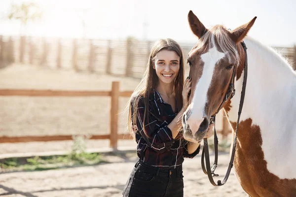 Retrato de menina de pé ao lado de um cavalo olhando para a câmera sorrindo . — Fotografia de Stock