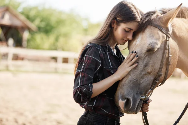 Genç kadın broodmare bir çiftlikte yeni bir at bir güneşli yaz gününde sevişme Portait.