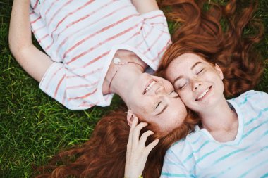 Birbirimiz hakkında bakmakta, parkta bir güneşli yaz gününde eğleniyor zencefil ikiz kız. Yakınları için dinleme önemlidir. Aile kavramı.