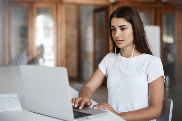 Junge schöne Grafik-Design-Startup-Besitzer, die eine Konferenzschaltung machen oder Streaming-Musik hören. Unternehmerkonzept. — Stockfoto