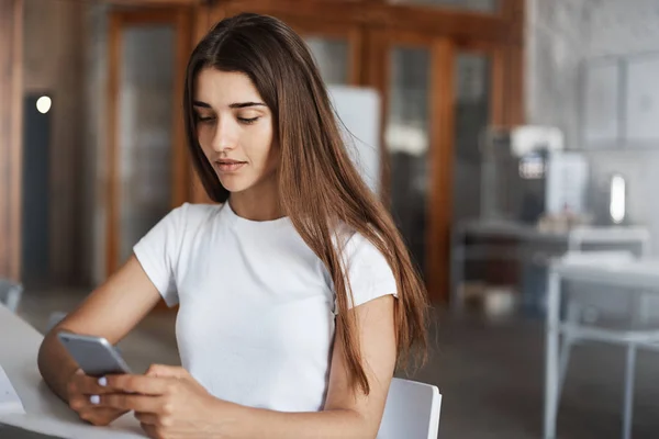 Wanita muda mencari pekerjaan menggunakan layanan online pada ponselnya. Profesional muda dalam permintaan setelah universitas . — Stok Foto