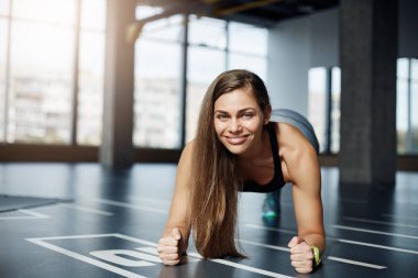 Bir spor salonu zemin üzerinde dirsek tahta egzersiz yaparak yetişkin güzel kadın portresi. Sağlıklı fitness vücut kavramı.