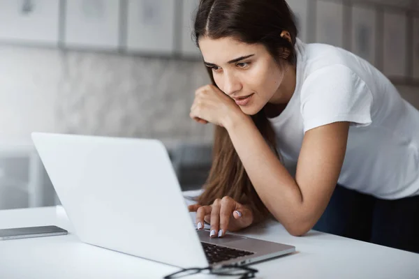 Online iş başvurusu için bir dizüstü bilgisayar kullanan genç kadının yakın çekim.