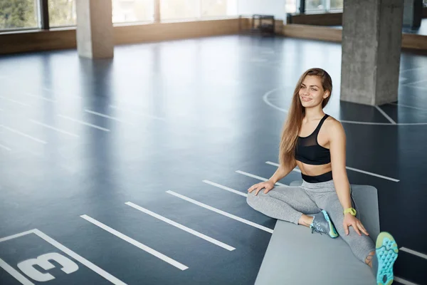 Wide shot of young beautiful fitness trainer stretching before a hard pilates training session. Perfect healthy body concept. — Stock Photo, Image