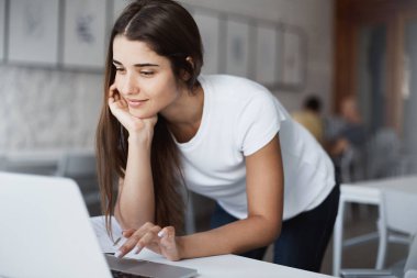 Dizüstü bilgisayar gülümseyen Halk Kütüphanesi olarak Internet üzerinde bilgi arama kullanan güzel beyaz kadın.