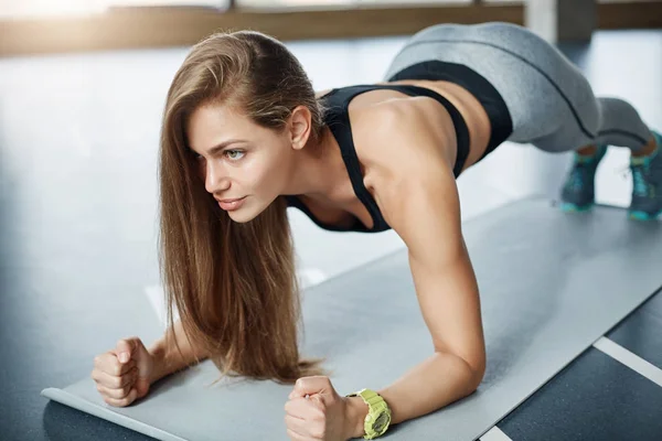 Forte treinador de fitness corpo mulher fazendo prancha para fortalecer seu bíceps tríceps e abdominais. Conceito de desporto feminino . — Fotografia de Stock