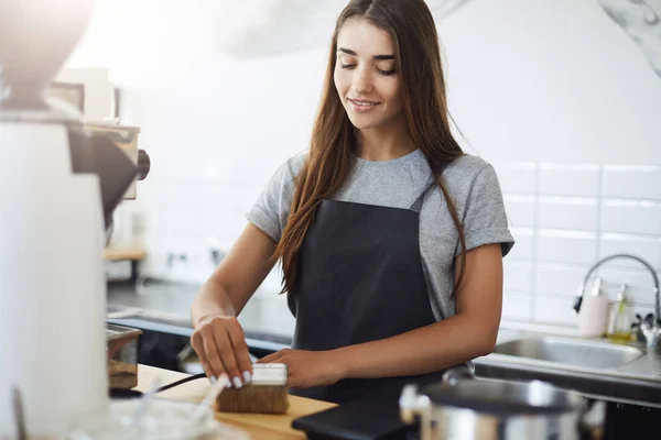Portrait of young and cute barista intern taking care of her work place cleaning everything with a brush. — Stock Photo, Image