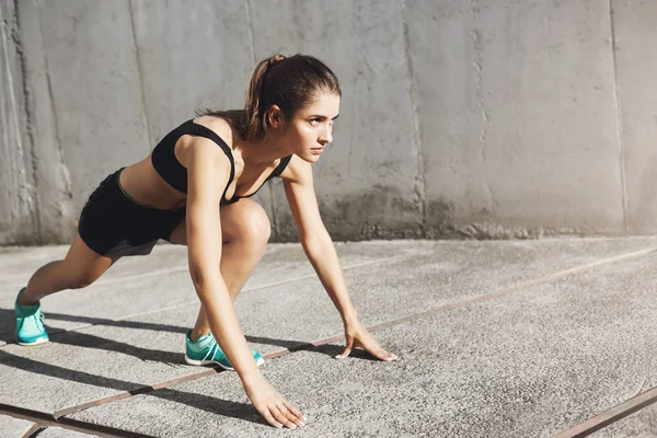 Porträt eines jungen, fitten Läufers, der bereit ist, durchzustarten. Frau kümmert sich um ihren sportlichen Körper. — Stockfoto