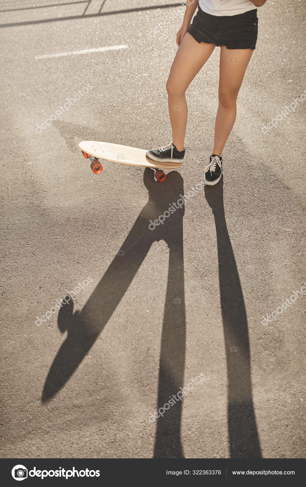 Vertical Shot Woman Legs In Shorts And Sneakers Lifting Up Skateboard Skater Girl Riding Penny Board Enjoy Summer Evening Active Activity Practice New Tricks Longboard Perform Stunts Royalty Free Photo Stock Image