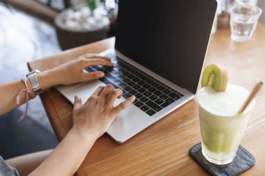 Kırpılmış kadın eli, serbest çalışan, dizüstü bilgisayarda çalışan, kokteyl içen, açık kafe bölgesinde oturan, alışveriş yapan ya da iş konuşan, uzaktan eğitim alan biri.