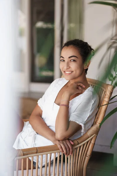 Vertical tiro tierno, lindo turista mujer oriental, sentarse sillón de ratán disfrutar de un clima cálido y soleado en la hermosa terraza, gire la cámara de la cara, sonriendo felizmente, relajarse de vacaciones, finalmente disfrutar de vacaciones —  Fotos de Stock