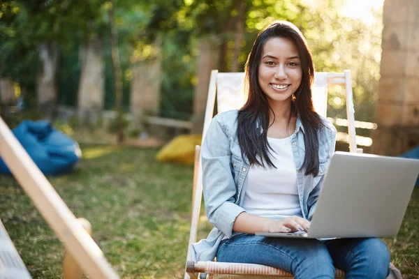 Freelance, vanlife e concetto di nomade digitale. Attraente giovane imprenditrice di successo lavorare all'aria aperta godersi la natura, sedersi nel parco sulla sedia da picnic, tenere il computer portatile in grembo sorridente fotocamera soddisfatto — Foto Stock