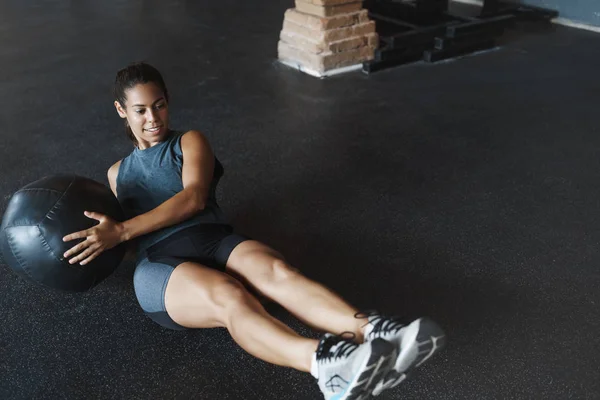 Motivated smiling, gorgeous hispanic woman in activewear, lie on floor with tighen muscles, lift and move med ball sideways as crunching abs, workout to make body perfect, functional training concept — 스톡 사진