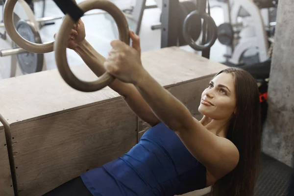 Motivation, strength and sport concept. Strong attractive female in activewear, attend gym, bought membership in fitness club, using gymnastic rings, hanging on functional training equipment — Stock Photo, Image