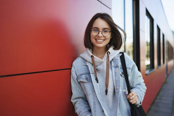Zasněný roztomilý úsměv žena v brýlích, exhange student procházky po kampusu, držení totebag, vypadající kamera bezstarostný a radostný, koncept mládí, moderní generace a kariéry — Stock fotografie
