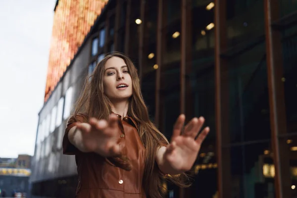 Sedutor sensual mulher dançando sonhador fora na movimentada rua da cidade, reacing mãos na câmera com flerte expressão romântica, tentando agarrar algo, andando para a frente, sentindo-se despreocupado Imagem De Stock