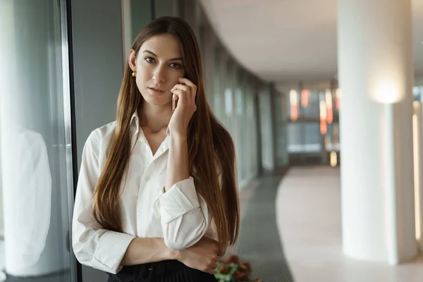 Focused and serious-looking businesswoman standing near window, thinking about presentation, practicing speech before business meeting, looking camera determined, touching face — Stock Photo, Image