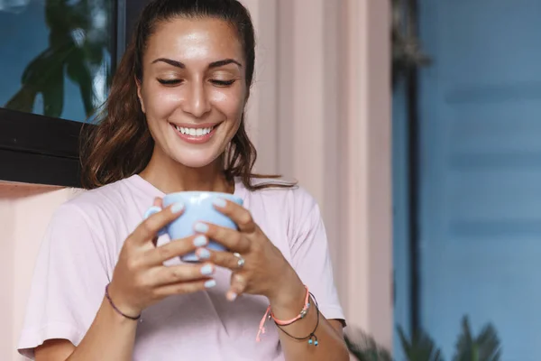 Chill and relaxed happy woman, smiling enjoying nice hot cup of coffee, self-quarantine, stay home to prevent spread of covid19 epidemic, feel safe and comfortable, enjoying self-care time