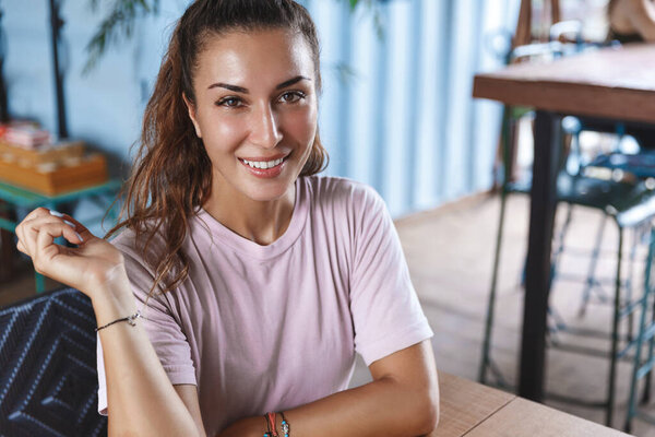 Close-up portrait of attractive european woman, tourist on vacation, female eating out, having lunch, making order as look at waiter with friendly smile, enjoying relaxing vacation on Bali island Stock Photo