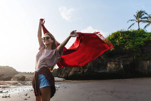 Vacanze estive, viaggi e relax. Donna felice spensierata alzare le mani, passeggiare lungo la spiaggia sabbiosa sull'isola tropicale, viaggiare a soleggiata calda Bali o Hawaii, contemplare le onde dell'oceano Fotografia Stock