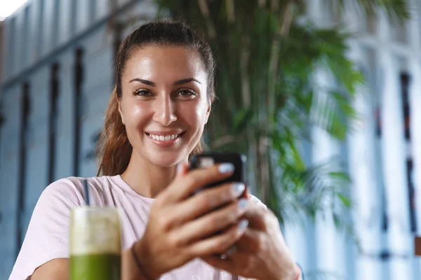 Egészséges életmód, emberek és szabadidős koncepció. Közelkép portré csinos kaukázusi női turista, nő használja a mobiltelefon, miközben iszik smoothie nyaralás, utazás a gyönyörű sziget pihenni — Stock Fotó