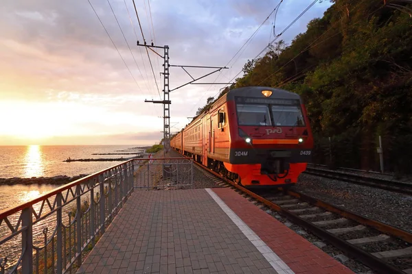 Passenger train during sunset rides along the coast of the Black — Stock Photo, Image