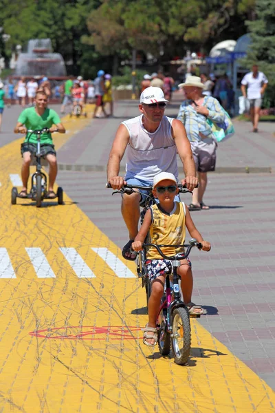 Otec a syn jezdit na cyklistické stezce na městském nábřeží — Stock fotografie