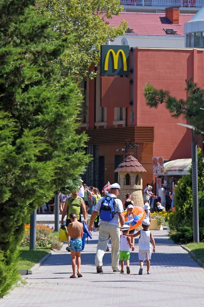 Dědeček s vnoučaty chodí do McDonaldovy kavárny v Ru — Stock fotografie