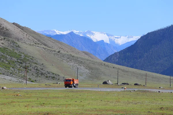 A car and a cow on the background of picturesque rocks in the Al — Stock Photo, Image