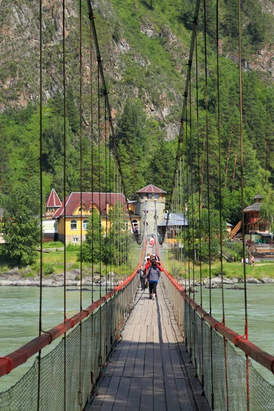 Suspension bridge over the Katun mountain river in the Altai mou — Stock Photo, Image