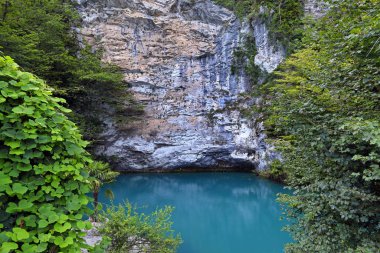 Abkh Cumhuriyeti 'nin Kafkasya dağlarındaki derin mavi göl.