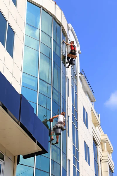 Raamreinigers werken aan een gebouw in de stad Krasnodar in s Stockfoto