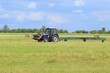 Sibirya 'da tırmıkla tırmıkla gezen traktör.