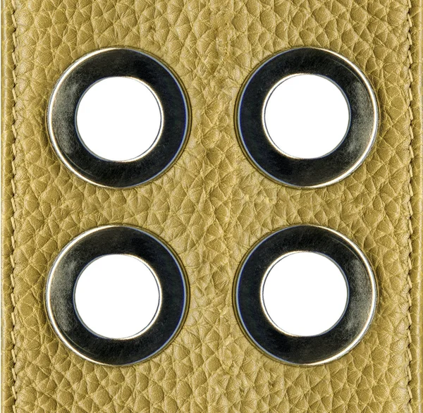 Vier dekorative Stahlringe auf gelbem Lederhintergrund — Stockfoto