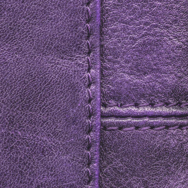 紫の革の質感は縫い目で飾られました。 — ストック写真