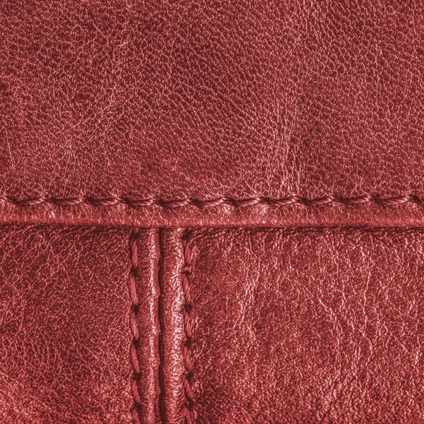 Red leather texture decorated with seams — Stock Photo, Image