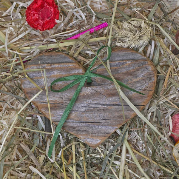 Coração de madeira no fundo de palha, decorado — Fotografia de Stock