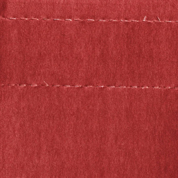 Fond de matériau synthétique rouge décoré de coutures — Photo