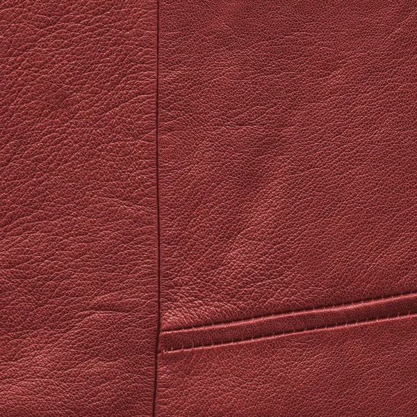 Красный кожаный фон, украшенный швами — стоковое фото