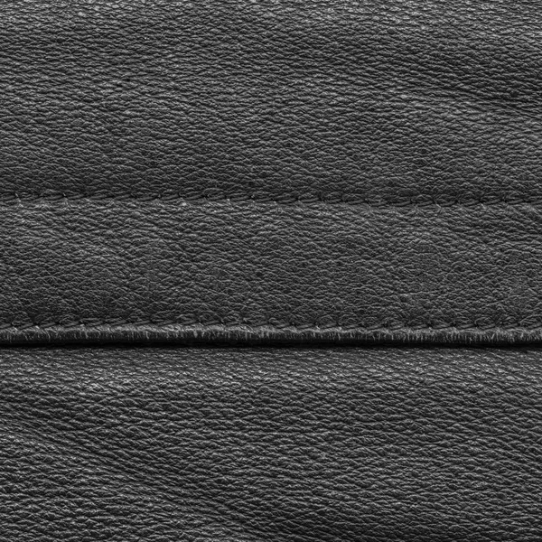 Черный кожаный фон, украшенный швами — стоковое фото