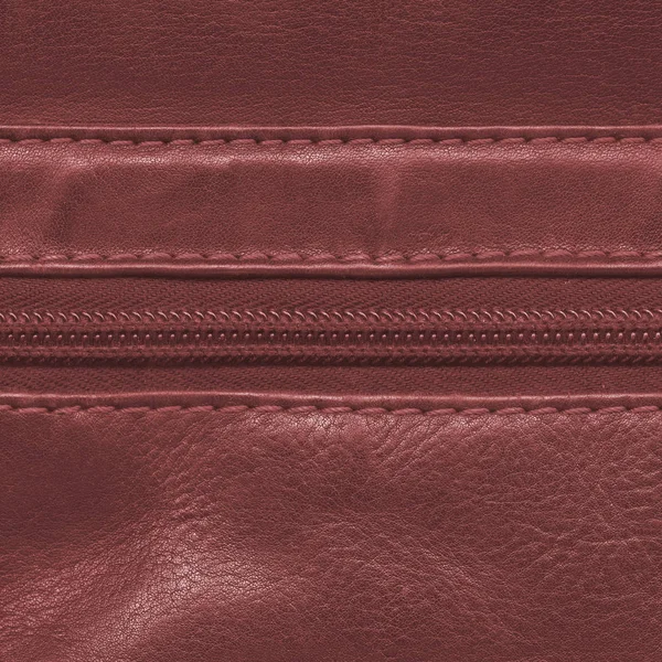 Red leather background, decorated with a zipper,seams — Stock Photo, Image