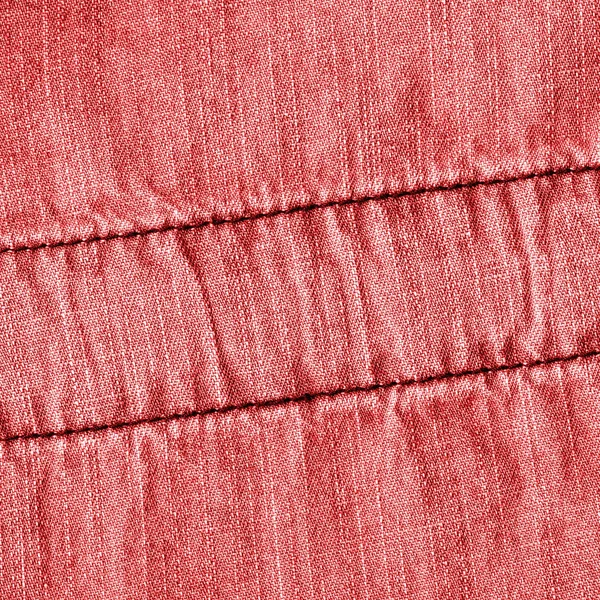 Červené džínové pozadí zdobí švy — Stock fotografie