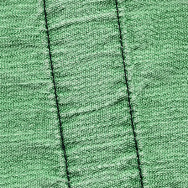 Pozadí zelené džínovina s švy — Stock fotografie