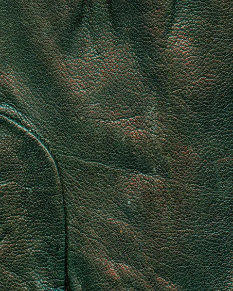 Fragment of old dark green glove as leather background — Stock Photo, Image