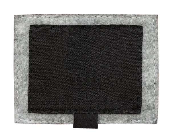 Blank black fabric tag on gray textile background — Stock Photo, Image